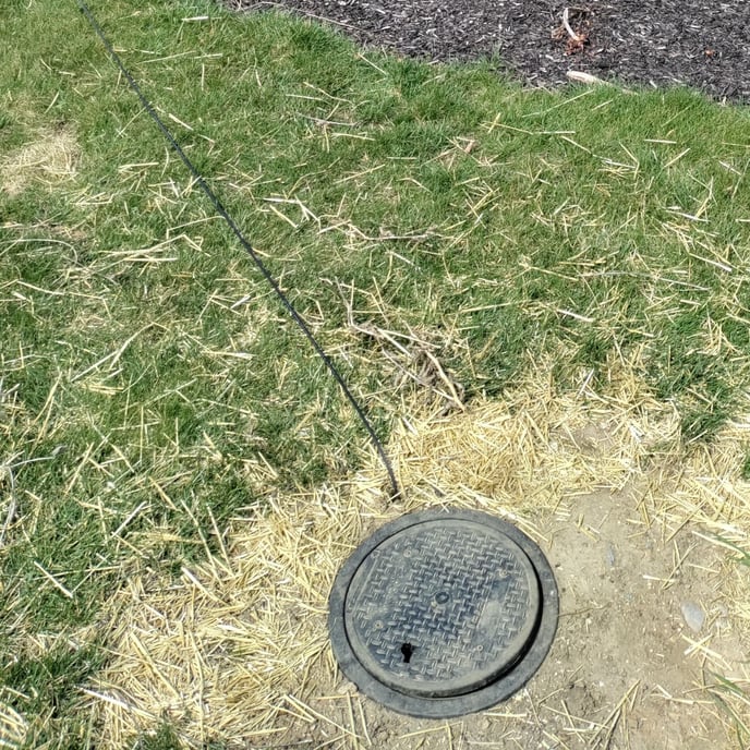 handhole in yard with fiber
